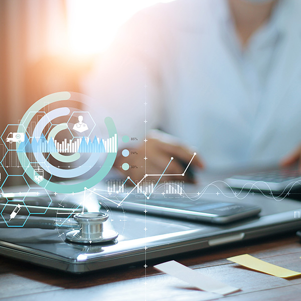 Doctor working on a laptop with graphics of health signs overlaid