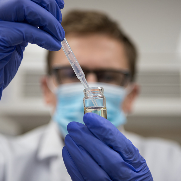 Scientist placing compound in a test tube