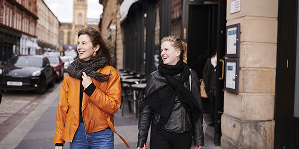 Two women walking down Candleriggs 