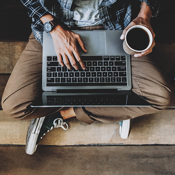 Man working on his laptop with a coffee