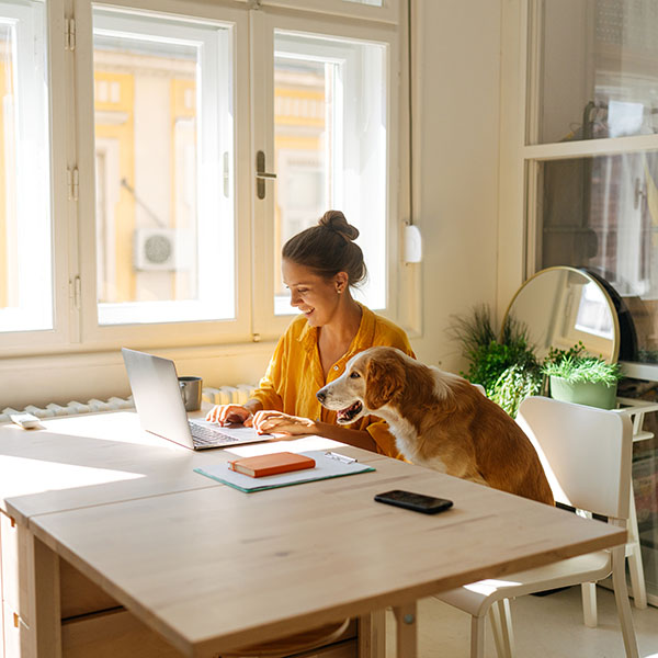 Women sitting at a laptop with her dog