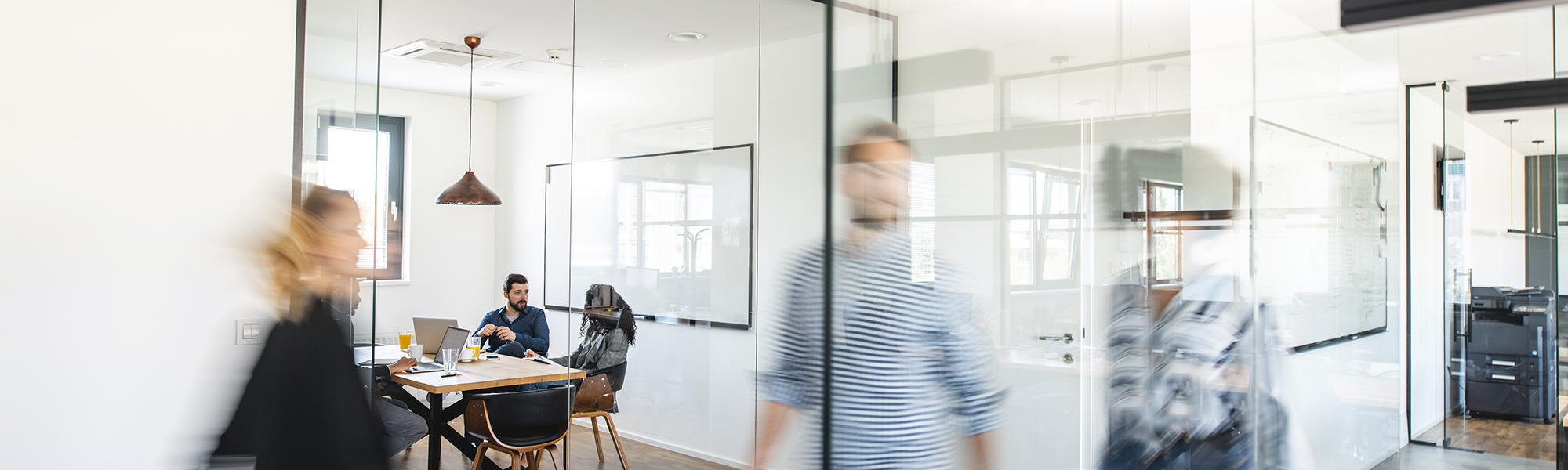 Modern day office with colleagues moving about the space