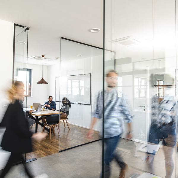 Modern day office with colleagues moving about the space