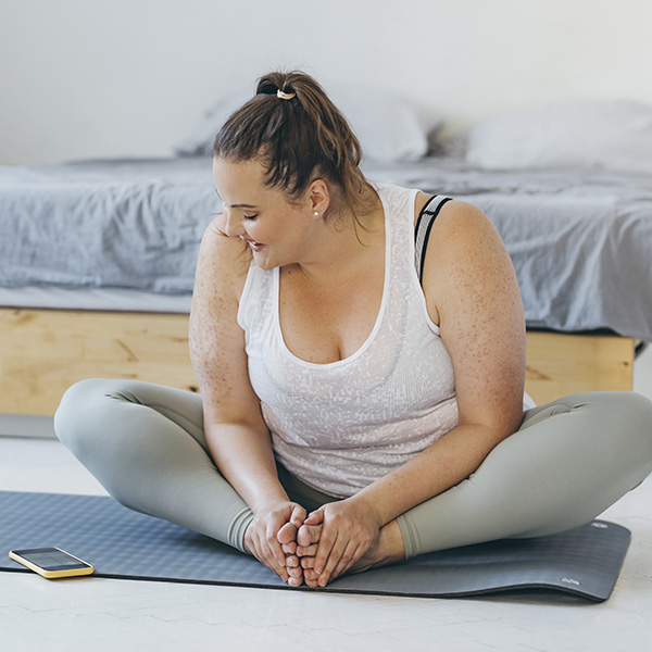 Woman doing yoga in her bedroom