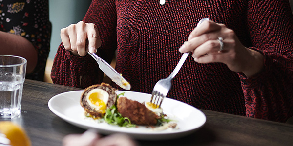 Woman eating a scotch egg