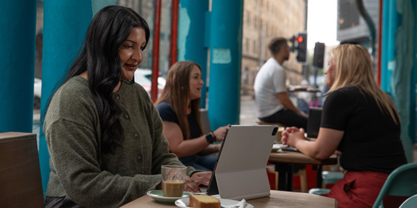 Woman on iPad reading in a cafe
